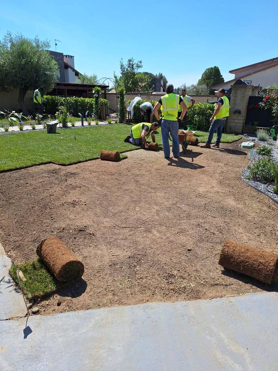 La squadra Enerverde durante la posa di un prato a rotoli in un giardino privato