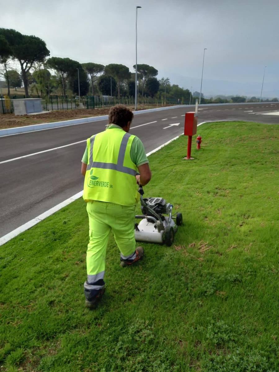 Operatore Enerverde durante lo sfalcio di un'aiuola stradale